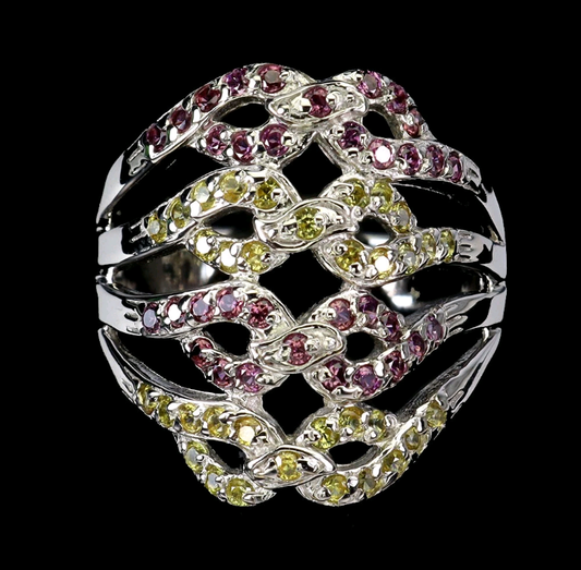 Silver ring with pink and green gemstones on a black background