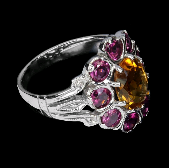 Close-up detail of oval citrine center stone with rhodolite garnet halo - natural untreated gemstones IF-VVS clarity