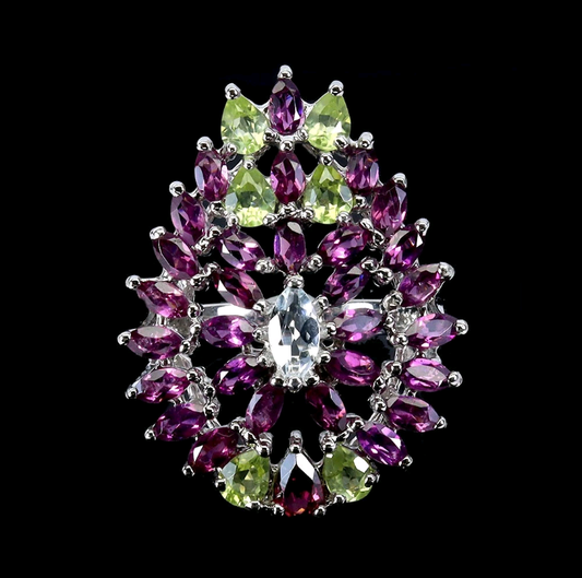 Jewelry piece with purple and green gemstones on a black background