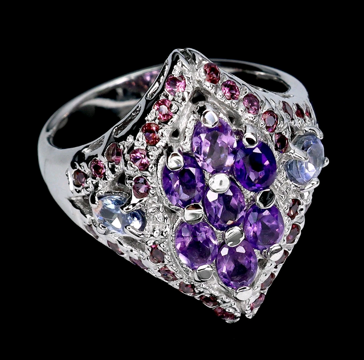 Silver ring with purple and pink gemstones on a black background