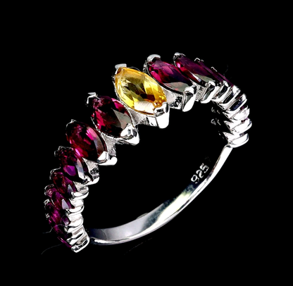 Silver ring with marquise-shaped gemstones on a black background