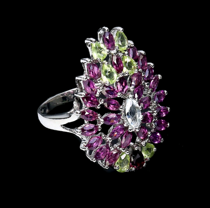 Ring with purple and green gemstones on a black background