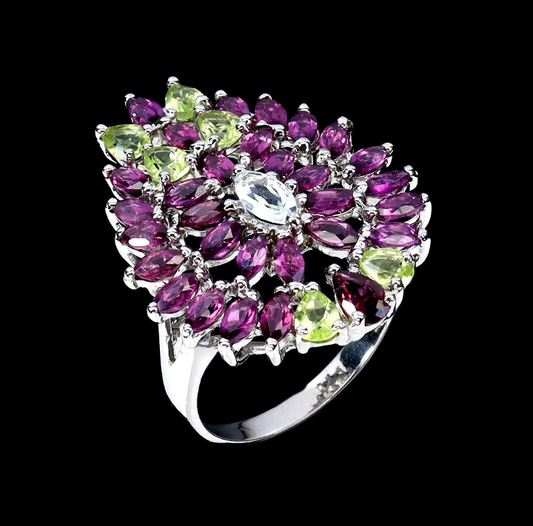 Silver ring with purple and green gemstones on a black background