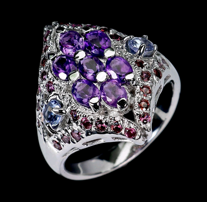 Silver ring with purple and blue gemstones on a black background