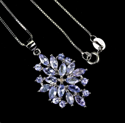 Necklace with a star-shaped pendant featuring purple gemstones on a black background