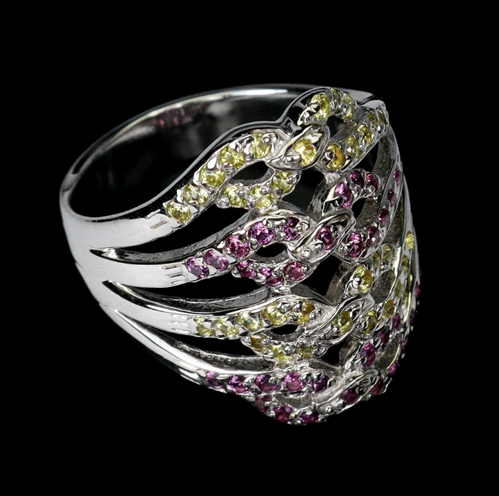 Silver ring with pink and yellow gemstones on a black background