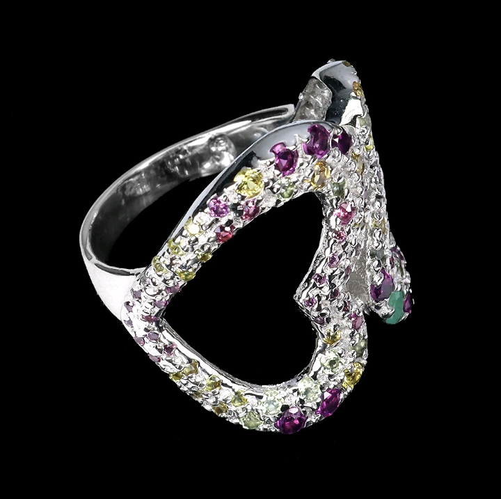 Silver ring with multicolored gemstones on a black background
