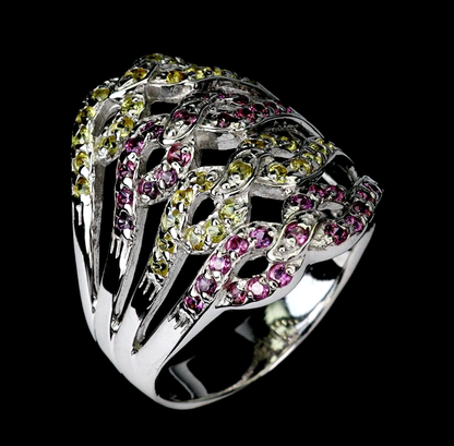 Silver ring with pink and green gemstones on a black background