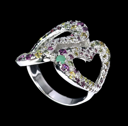 Silver ring with multicolored gemstones on a black background