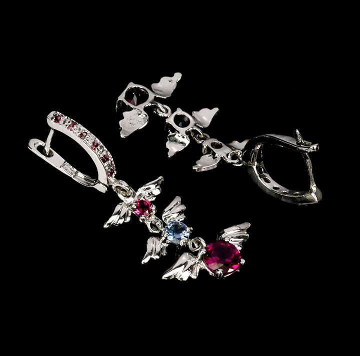 Silver butterfly earrings with gemstones on a black background