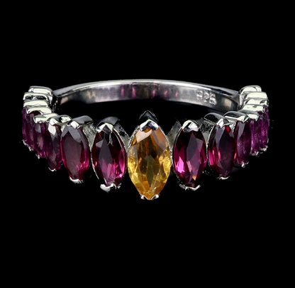 Silver ring with marquise-shaped gemstones on a black background