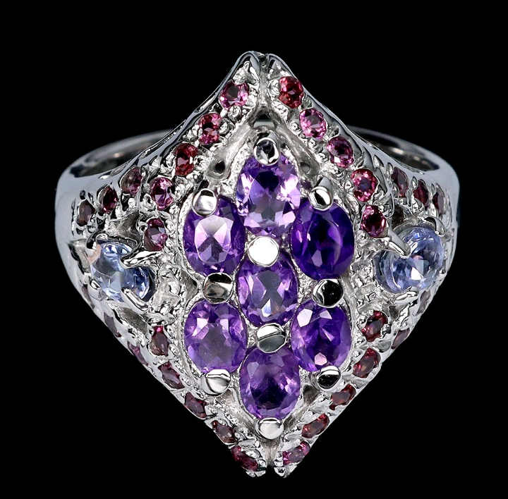 Ring with purple gemstones and silver accents on a black background