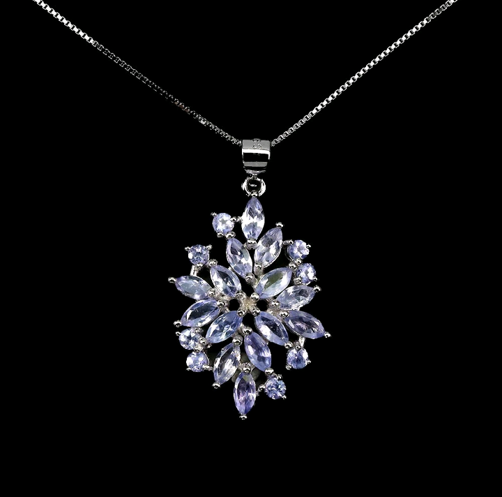 Silver necklace with a star-shaped pendant featuring purple stones on a black background