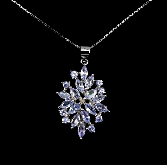 Silver necklace with a star-shaped pendant featuring purple stones on a black background