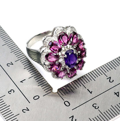 Silver ring with purple gemstones on a metal ruler